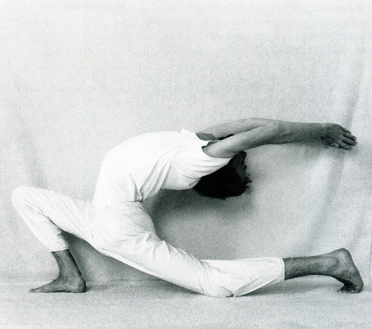 A person in a kneeling low lunge with the chest lifted and one arm reaching forward