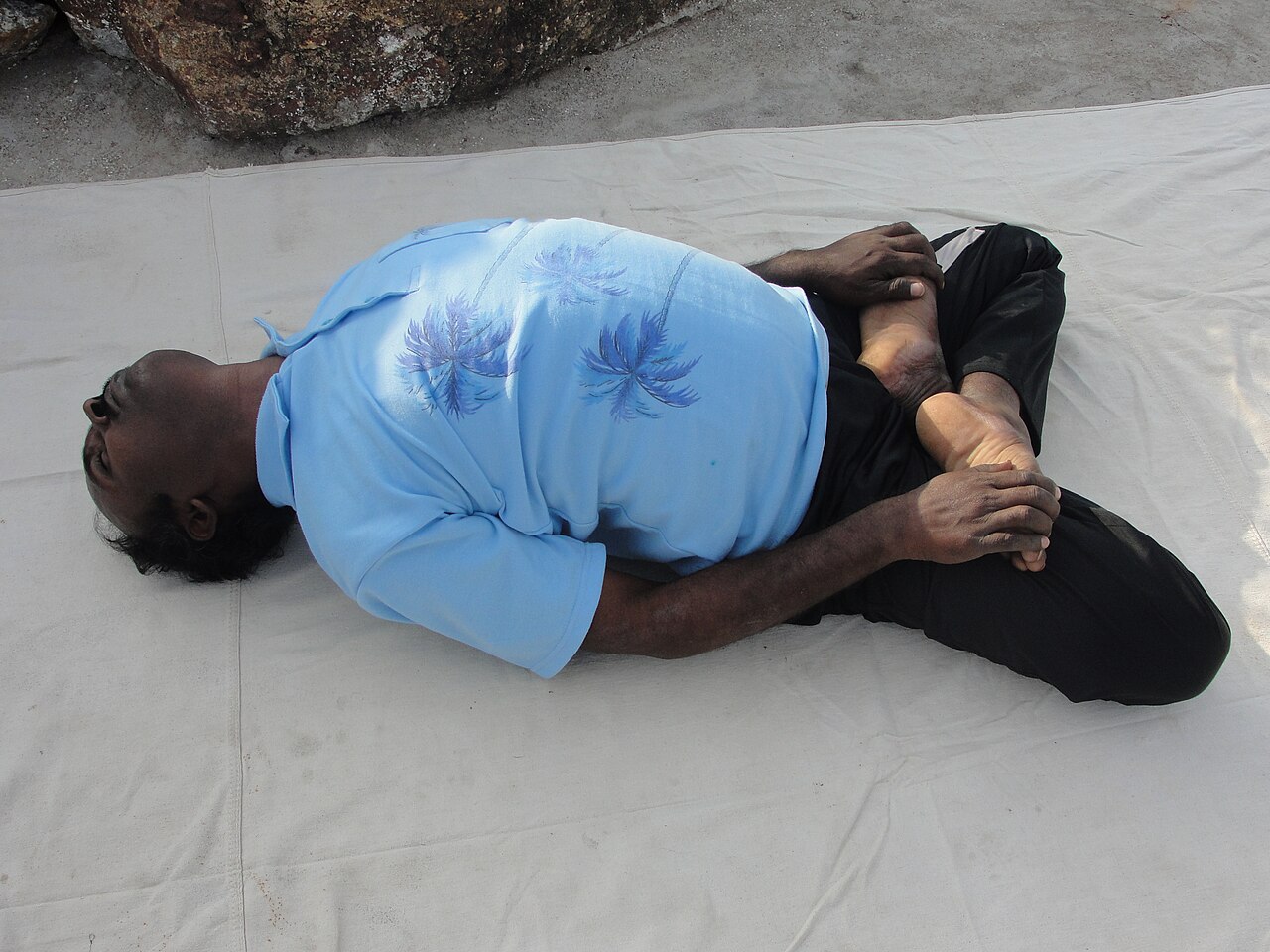 A person lying in Fish Pose with the chest lifted and the head resting back