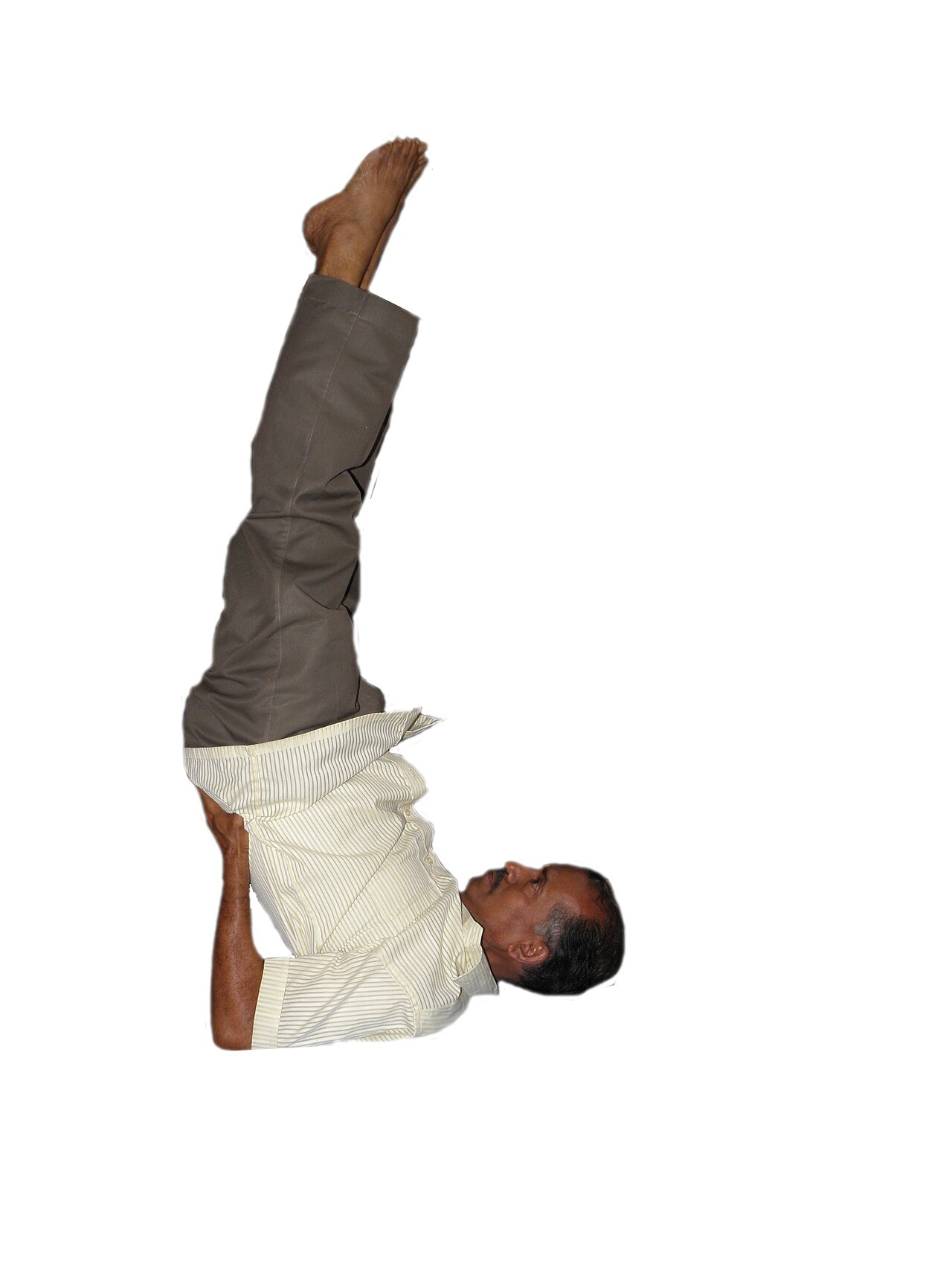 A person in Shoulderstand with the body stacked over the shoulders and legs vertical