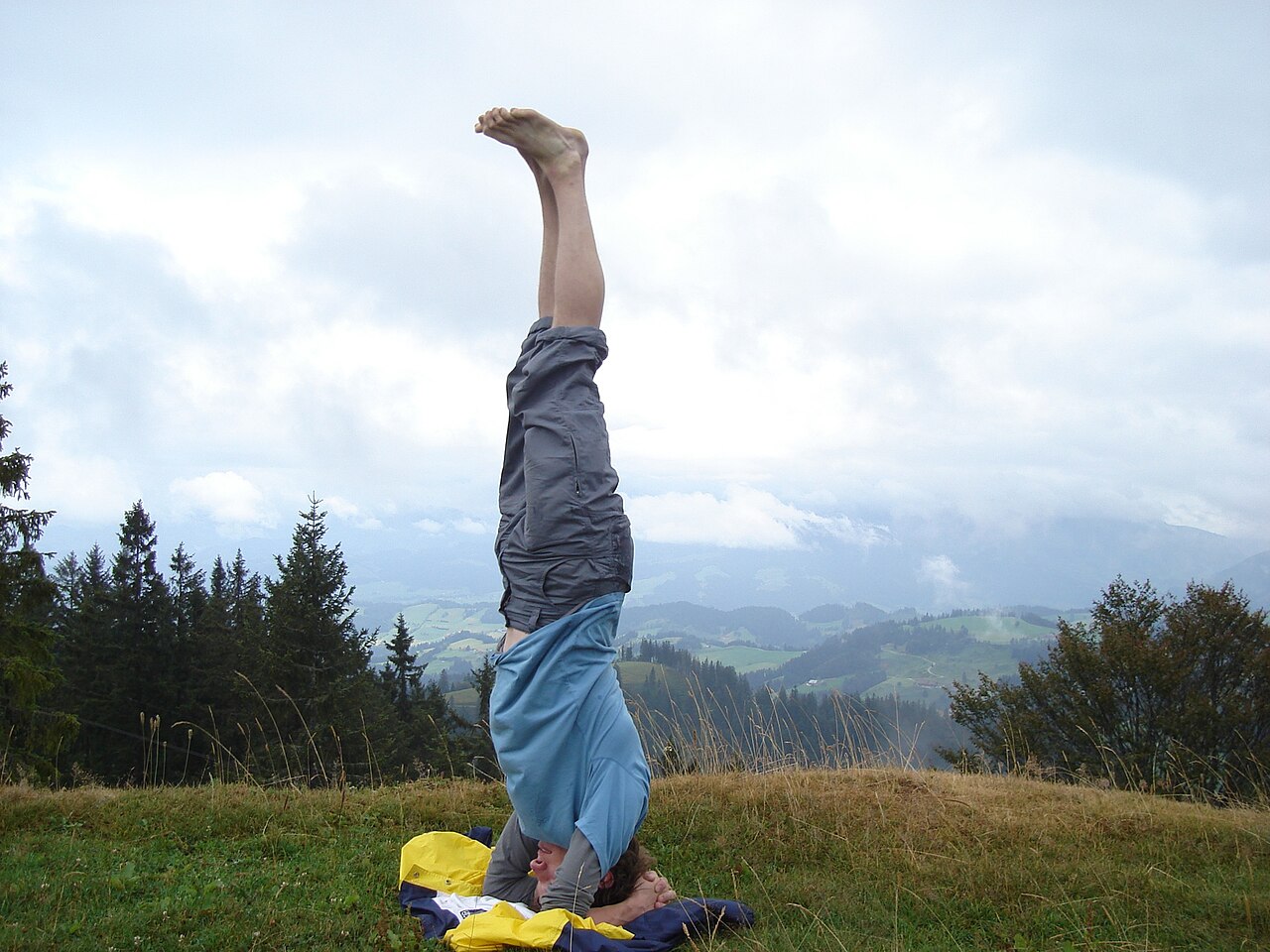 A person balancing in Headstand on the crown of the head with legs extended upward
