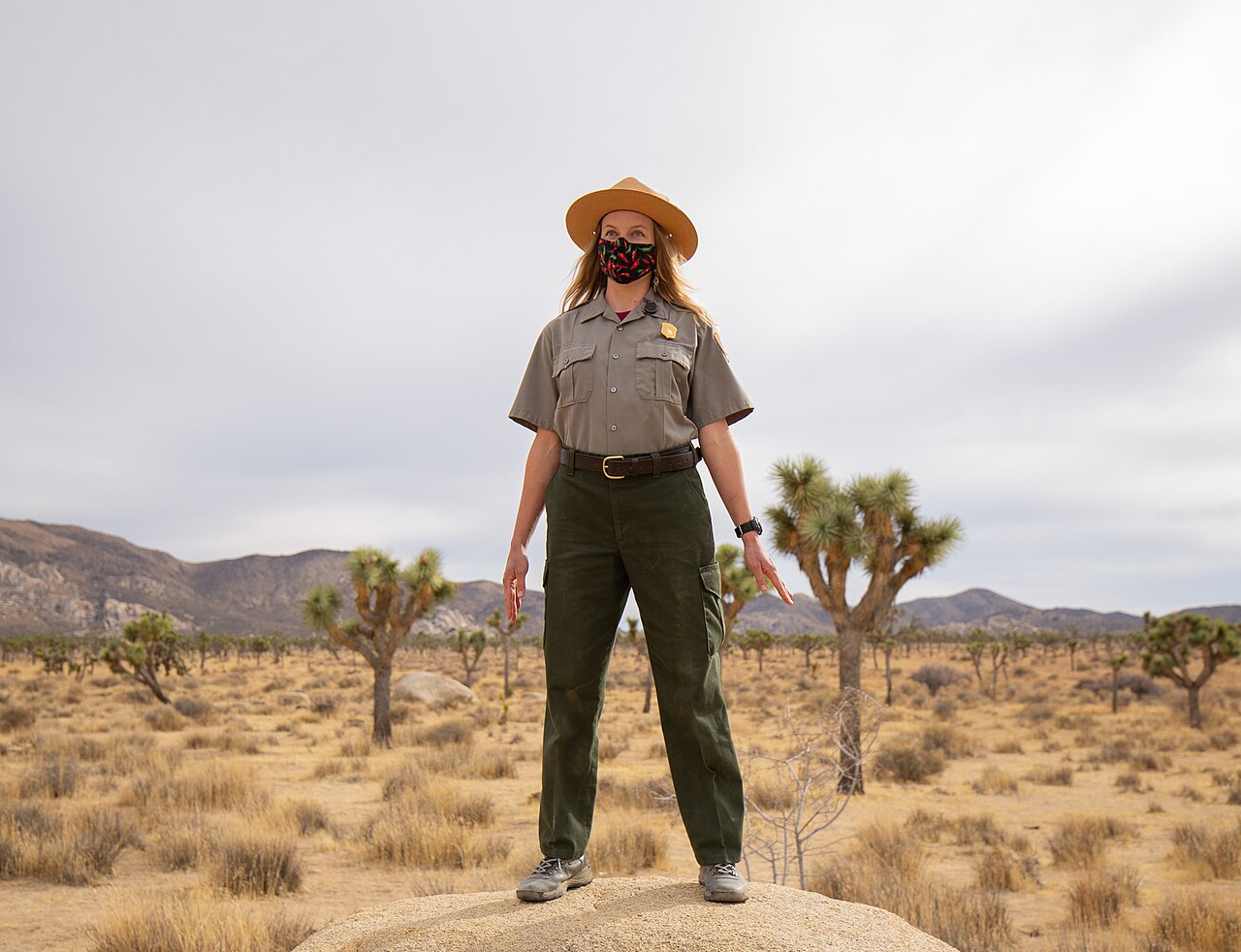 A person standing tall in Mountain Pose with feet together and arms relaxed at the sides